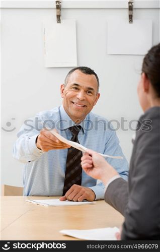 Man passing file to colleague
