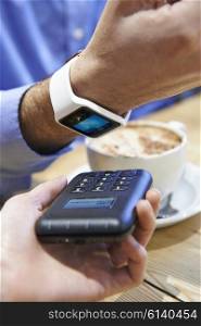 Man Paying In Coffee Shop Using Contactless Payment App On Smart Watch