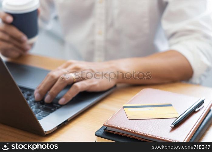 Man paying with credit card and entering security code for online shoping making a payment or purchasing goods on the internet with laptop computer, online shopping concept.