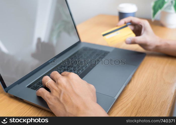 Man paying with credit card and entering security code for online shoping making a payment or purchasing goods on the internet with laptop computer, online shopping concept.