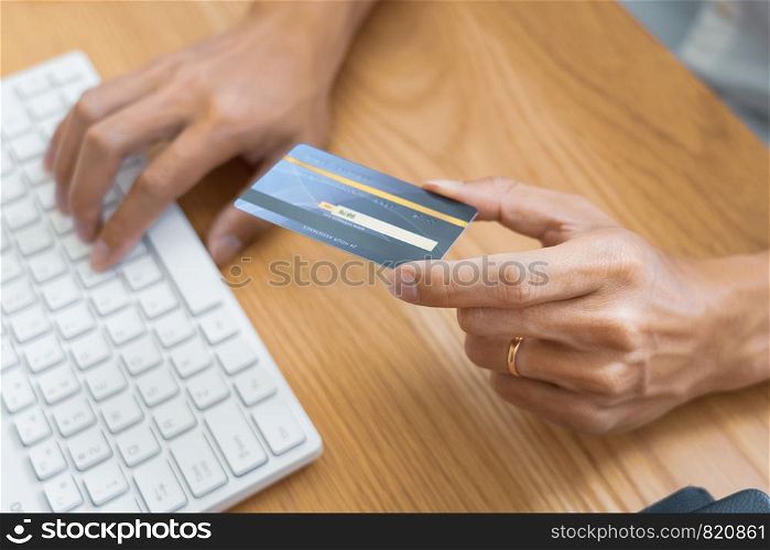 Man paying with credit card and entering security code for online shoping making a payment or purchasing goods on the internet with laptop computer, online shopping concept.