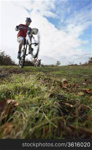 Man performing wheeley on mountain bike in countryside