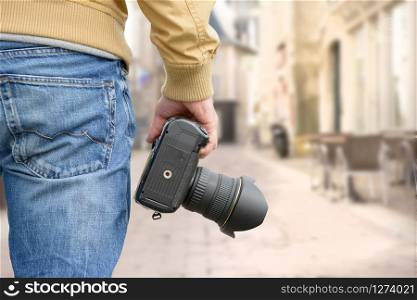 man photographer holding his photo camera, outdoor