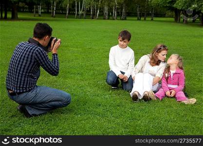 man photographes his family outdoors