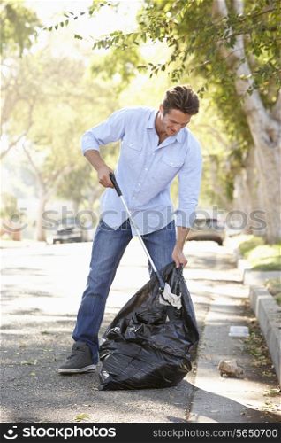 Man Picking Up Litter In Suburban Street