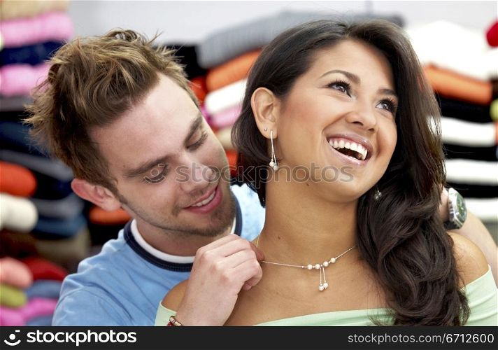 man placing a necklace gift to his girlfriend