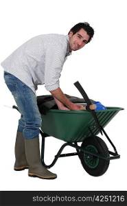 Man placing his personal belongings in a wheelbarrow