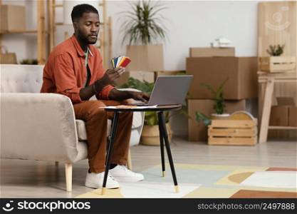 man planning redecorating home using color palette laptop