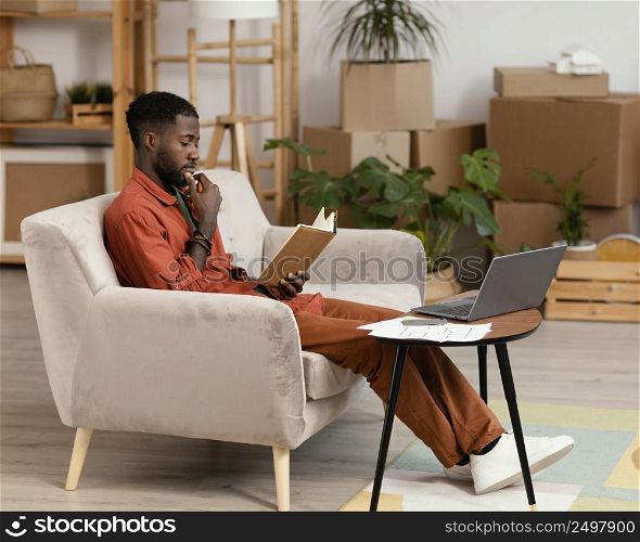 man planning redecorating home using laptop book