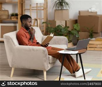 man planning redecorating home using laptop book
