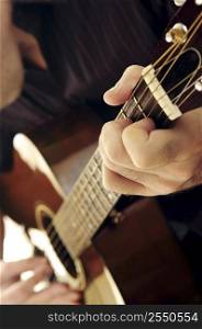 Man playing a musical instrument accoustic guitar