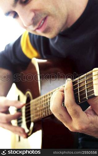 Man playing a musical instrument accoustic guitar