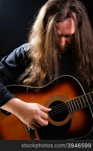 Man playing acoustic guitar over black background