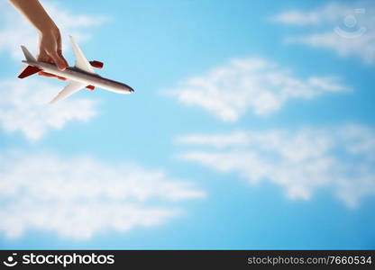 Man playing airplane toy against blue sky