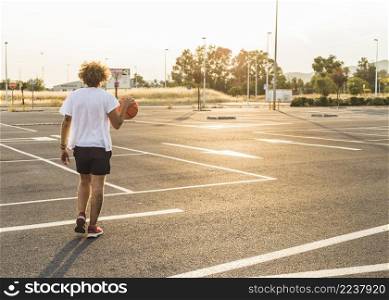 man playing basket ball court during sunny day