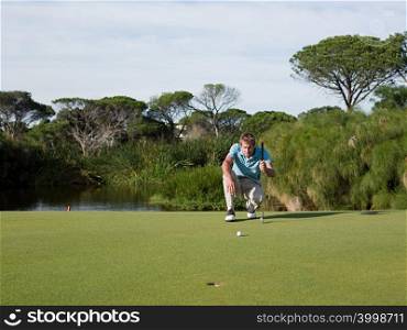 Man playing golf, on putting green