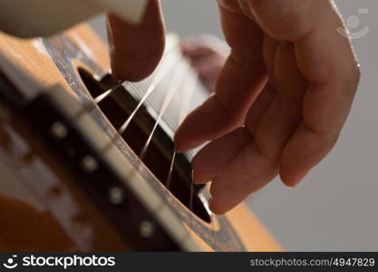 Man playing guitar. Close up of male hands playing acoustic guitar