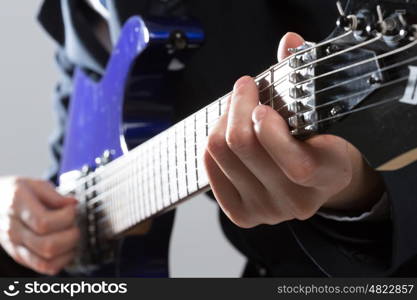 Man playing guitar. Close up of male hands playing electric guitar