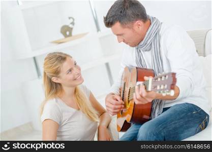 Man playing guitar to lady