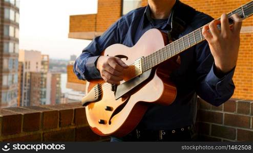 Man Playing Jazz Guitar on Balcony