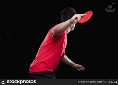 Man playing ping pong, black background
