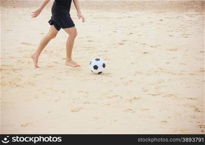 Man playing soccer ball on the beach