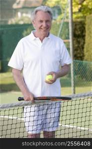 Man playing tennis and smiling