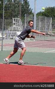 Man playing tennis on a hard court