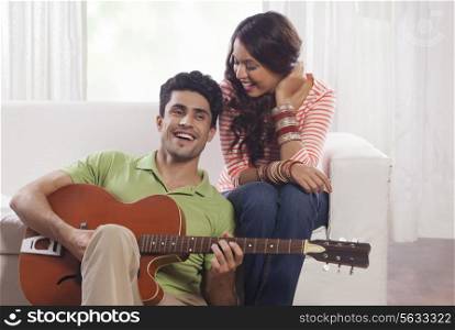 Man playing the guitar for his girlfriend