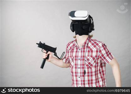 Man playing video game wearing virtual reality device holding gun. Gaming equipment for gamers concept.. Gamer man wearing VR holding gun