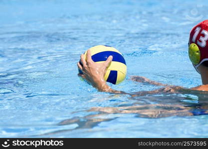 Man playing water polo in a swimming pool