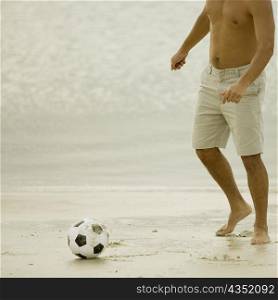 Man playing with a soccer ball on the beach