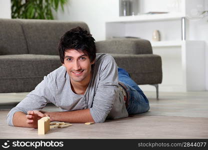 Man playing with dominoes at home