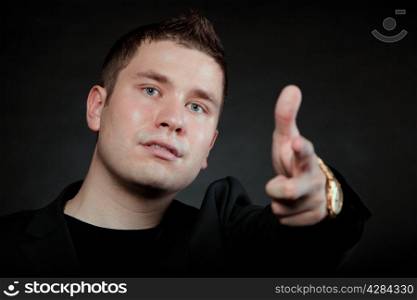 man pointing a finger towards you or at something interesting black background