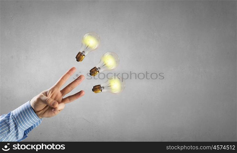 Man pointing light bulb. Businessman pointing with finger on glass glowing light bulb on dark background