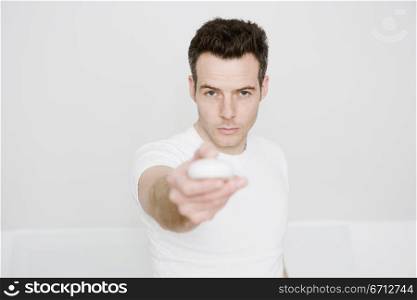 man pointing remote controls at camera