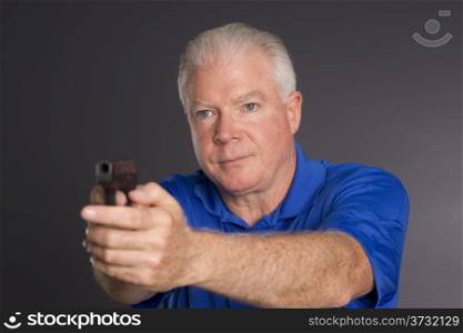 Man points small caliber semi automatic handgun to off camera left