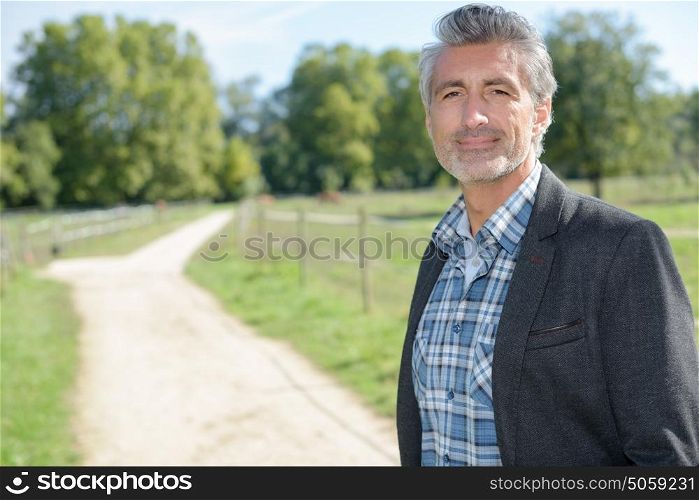 man posing in country lane