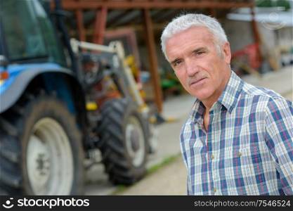 man posing with a tractor