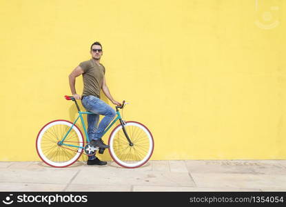 Man posing with his fixed gear bicycle wearing sunglasses