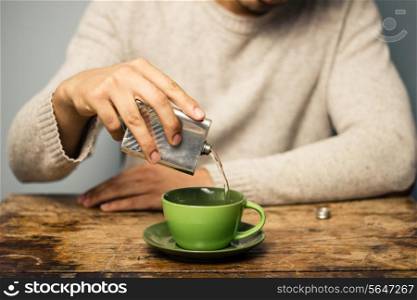 Man pouring alcohol in his coffee