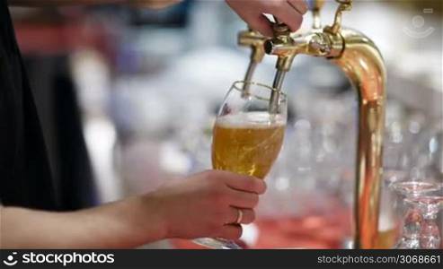 Man pouring full glass of draft beer, then turning off the tap and leaving