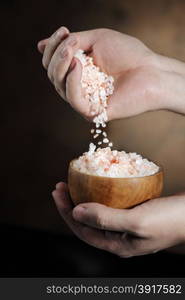 Man pouring himalayan salt crystals from his hand.