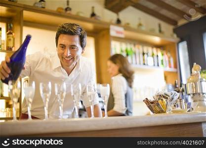 Man pouring wine in cafe