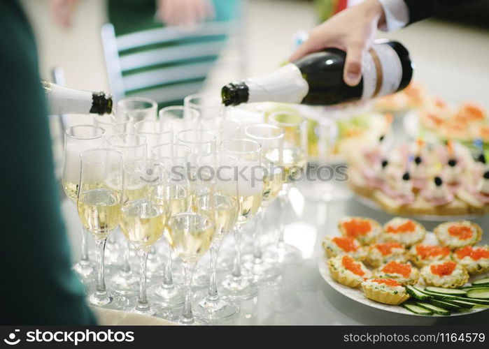 Man pours champagne into a glass close up. Man pours champagne into a glass from a bottle