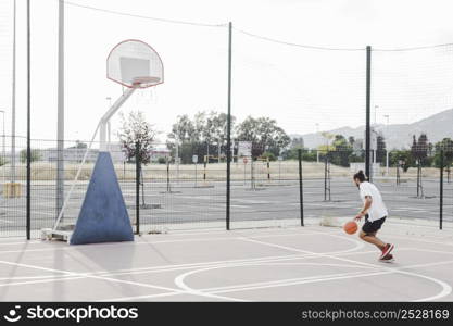 man practicing basketball near hoop outdoors court