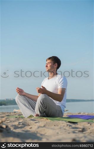Man practicing yoga against a sea background
