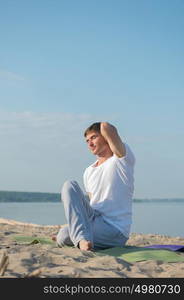 Man practicing yoga against a sea background