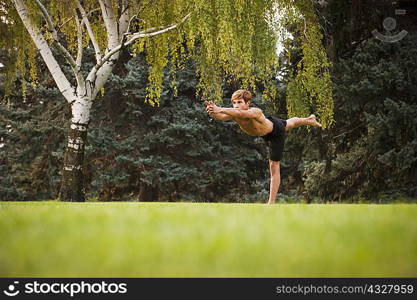 Man practicing yoga in park