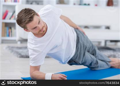 man practicing yoga on floor